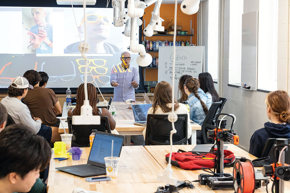 Ian Roy teaching in a classroom with prototype visuals on the projector
